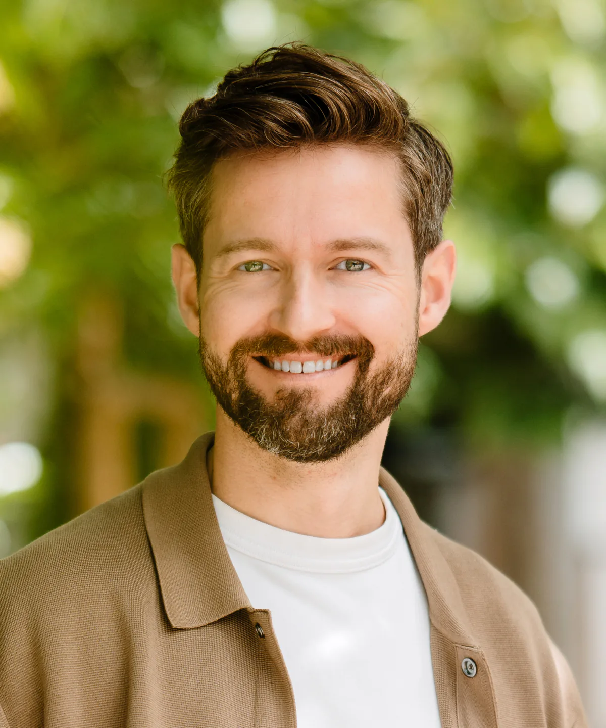 Henrik Gebbing, smiling, in a tan jacket, outdoors.